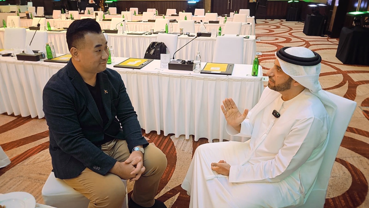 a man sitting in a chair with a man in a white robe