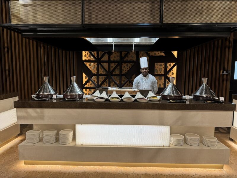 a chef standing behind a counter with food on it