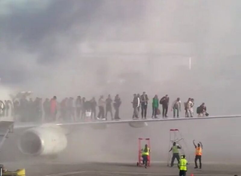 a group of people standing on a plane wing