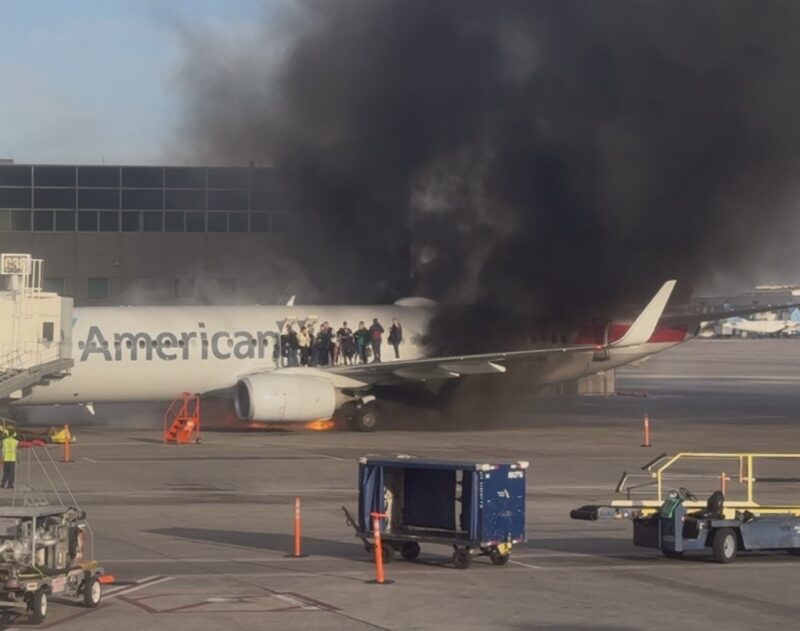 a plane on fire with people on the wing