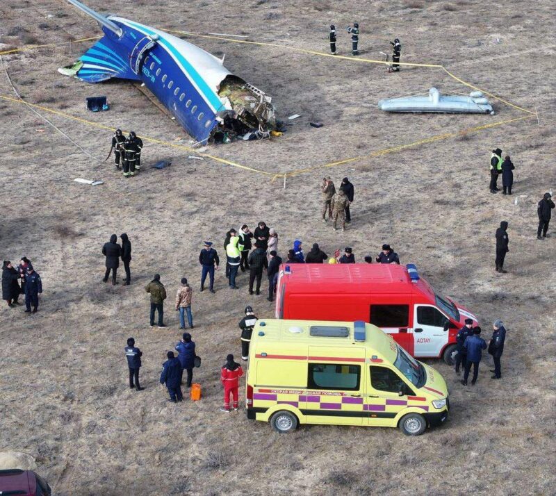 a group of people around a crashed plane