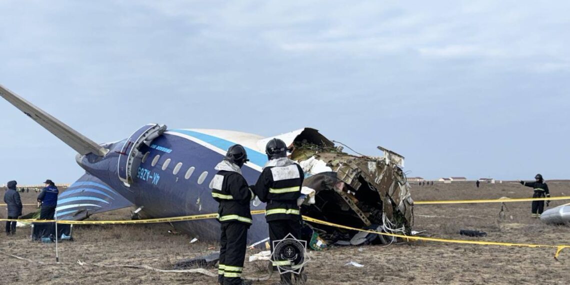 a group of people standing next to a crashed plane