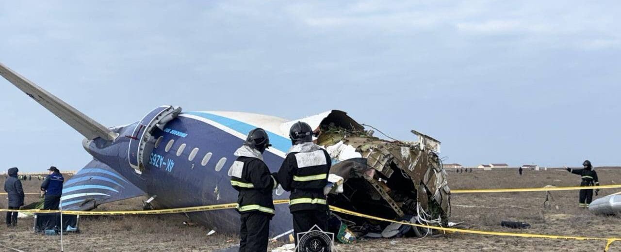 a group of people standing next to a crashed plane