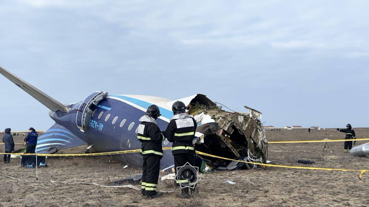 a group of people standing next to a crashed plane