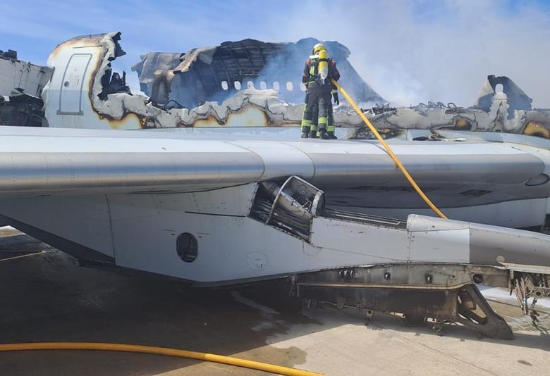 a fireman standing on the wing of an airplane