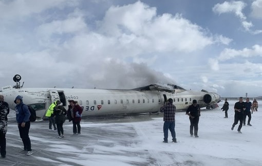 a group of people standing next to an airplane on snow