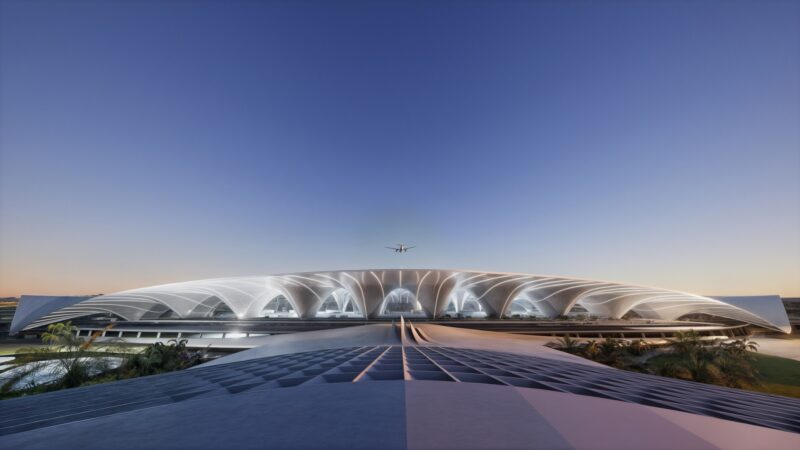 a plane flying over a large white building