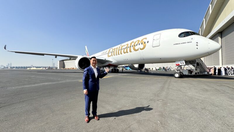 a man in a suit standing in front of an airplane