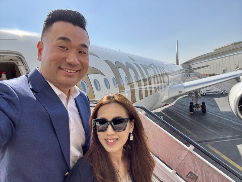 a man and woman taking a selfie in front of an airplane