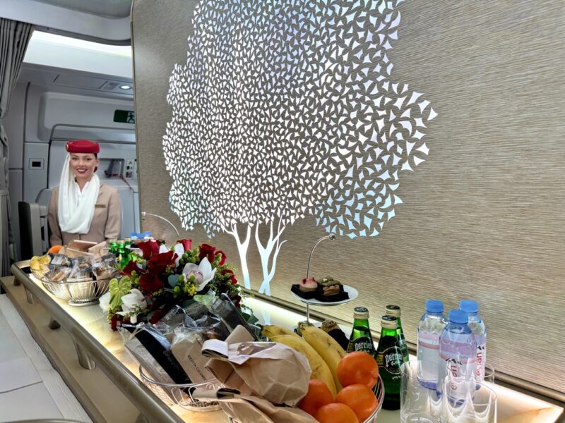 a woman standing behind a counter with food and drinks