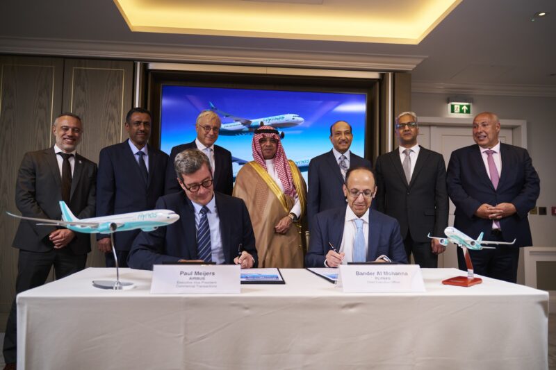 a group of men standing around a table with airplanes