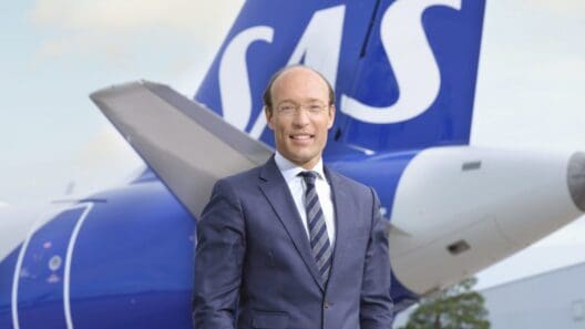 a man in a suit standing in front of a plane