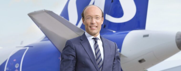 a man in a suit standing in front of a plane