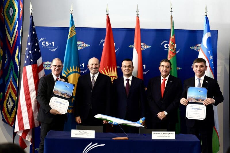 a group of men standing in front of a table with flags