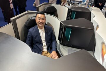 a man sitting in a chair with computer monitors