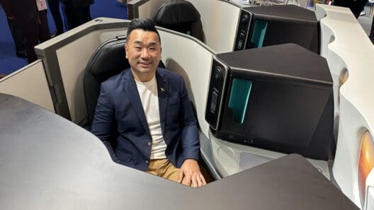 a man sitting in a chair with computer monitors