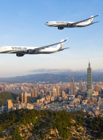 two airplanes flying over a city