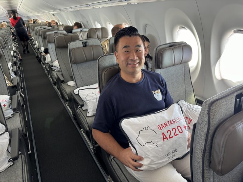 a man sitting on an airplane with a pillow