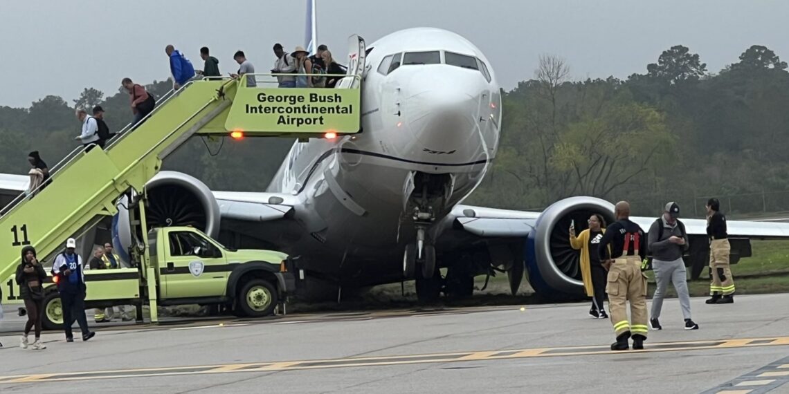 a group of people standing next to a plane