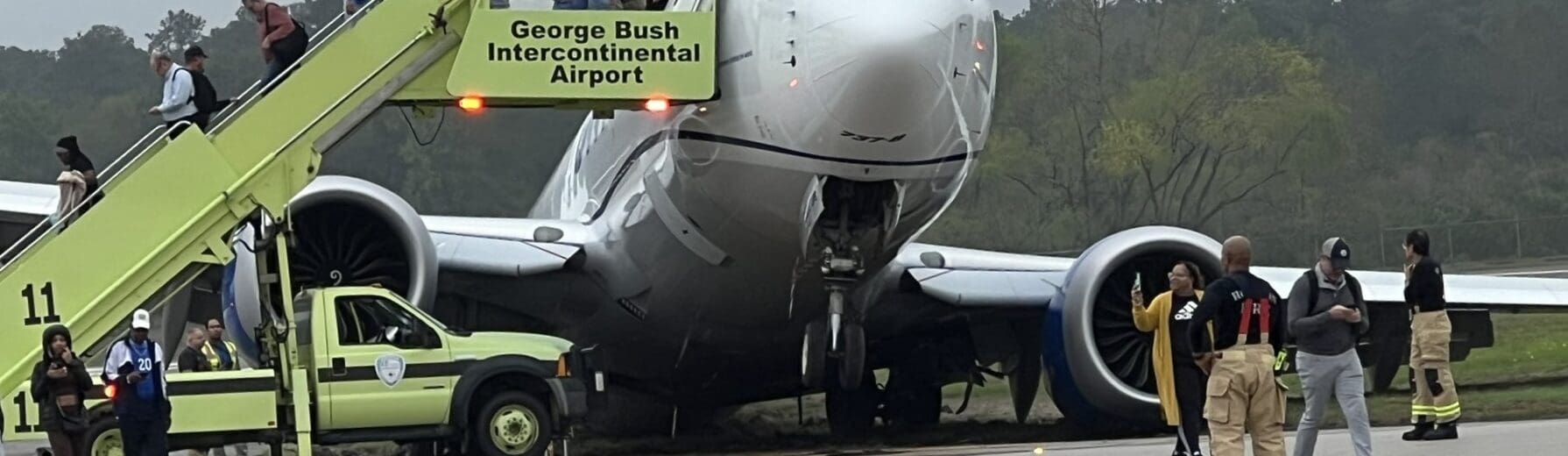 a group of people standing next to a plane