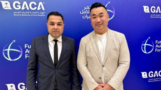 two men standing in front of a blue wall