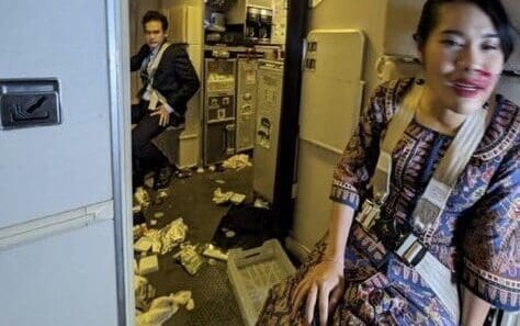 a woman sitting in a room with a man sitting on the floor