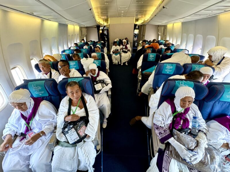 a group of people in white robes on a plane