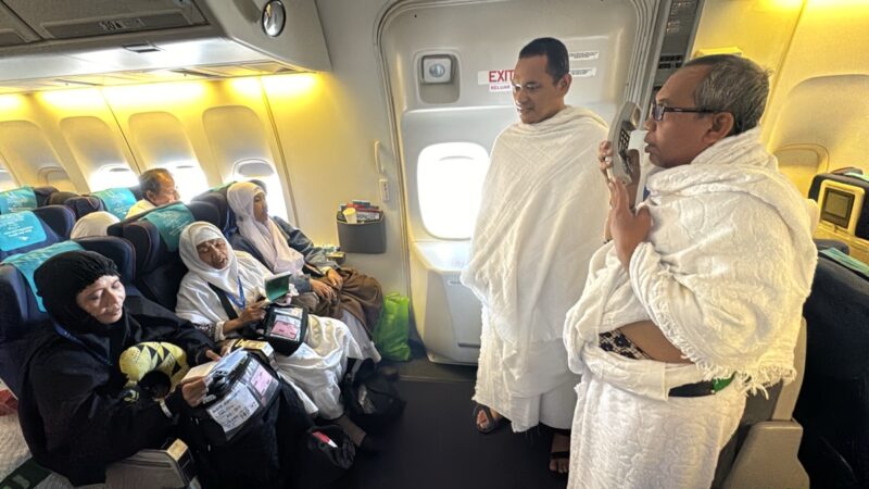 a group of people in white robes on an airplane