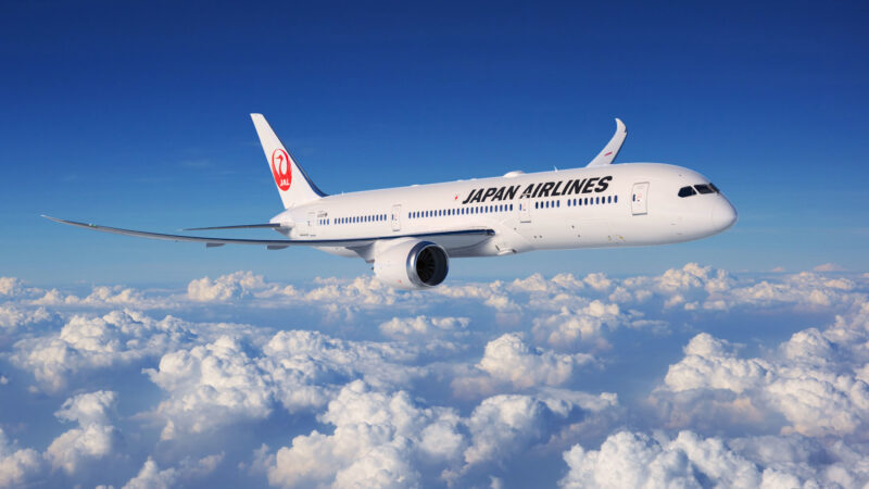 a white airplane flying above clouds