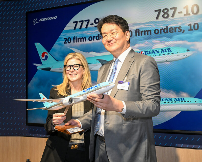 a man and woman holding a model airplane