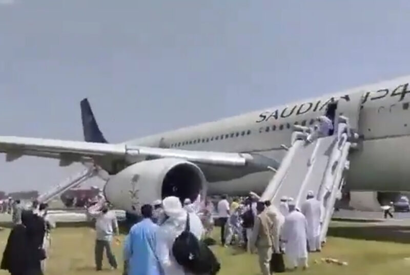 a group of people standing next to an airplane