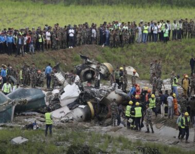 a group of people standing around a crashed plane