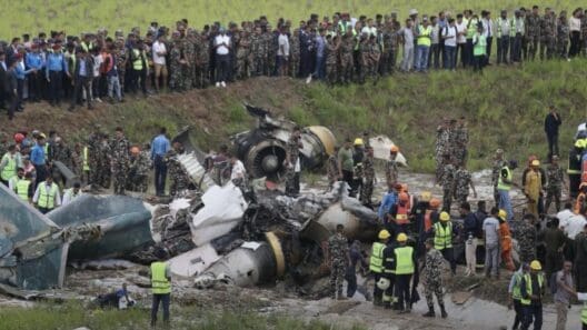 a group of people standing around a crashed plane