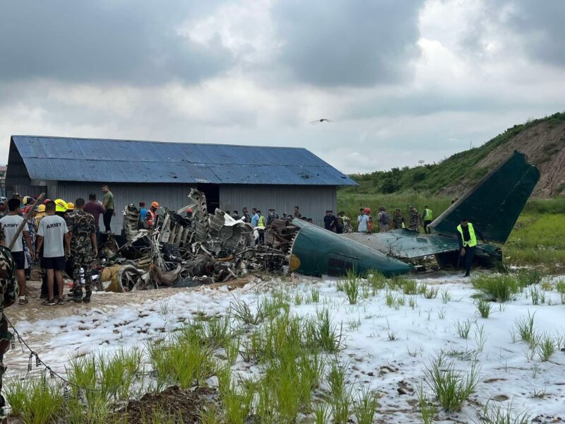 a group of people standing around a crashed plane