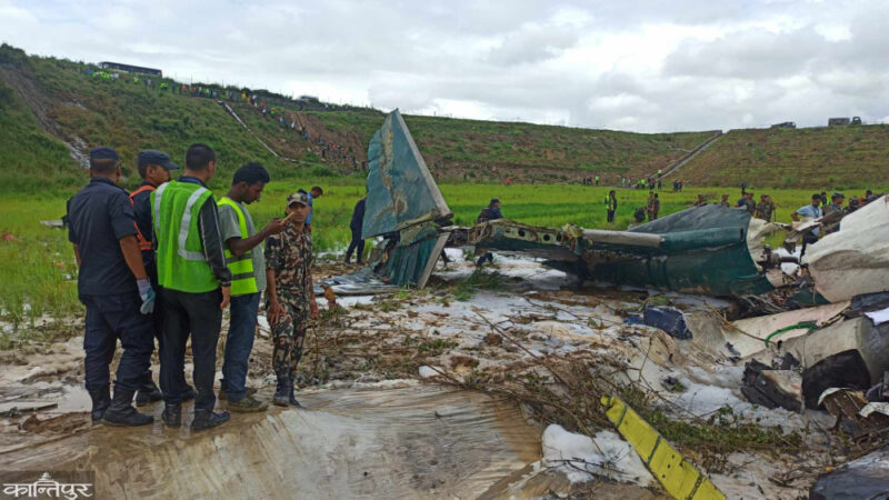 a group of people standing next to a crashed plane