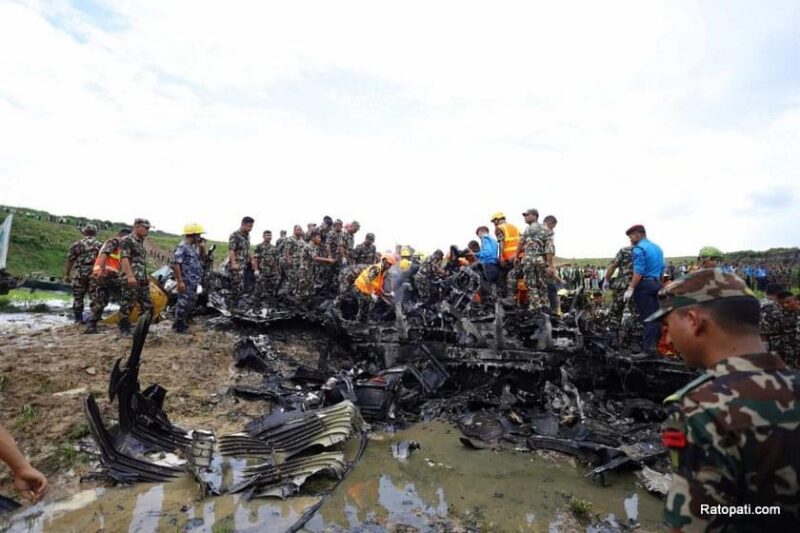 a group of people standing on a destroyed vehicle