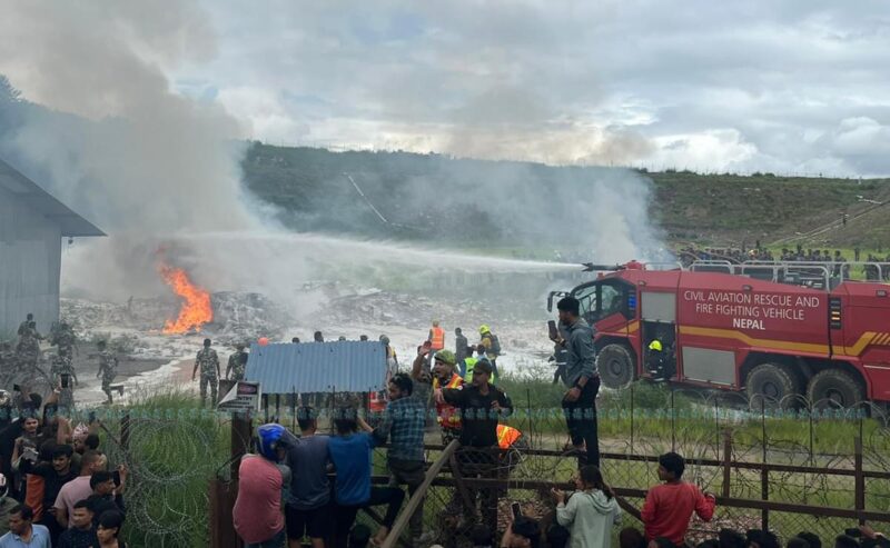 a group of people watching a fire on a field