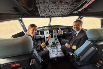 a man and woman sitting in a cockpit of an airplane