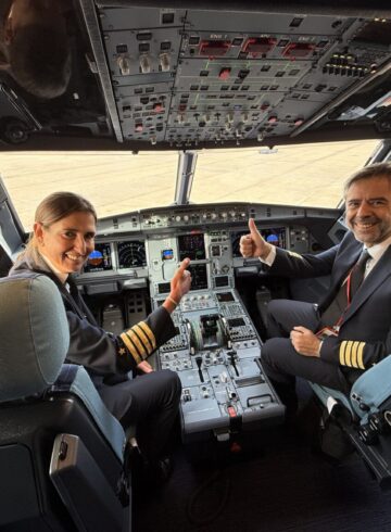 a man and woman sitting in a cockpit of an airplane