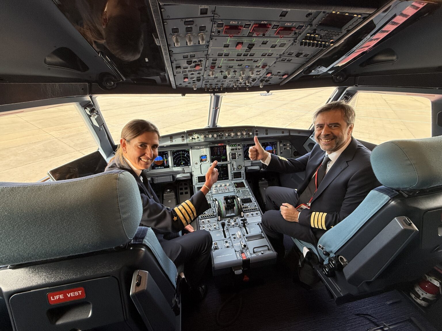 a man and woman sitting in a cockpit of an airplane