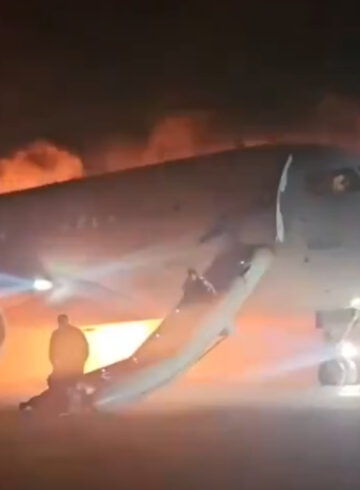 a plane with a man standing on the ground