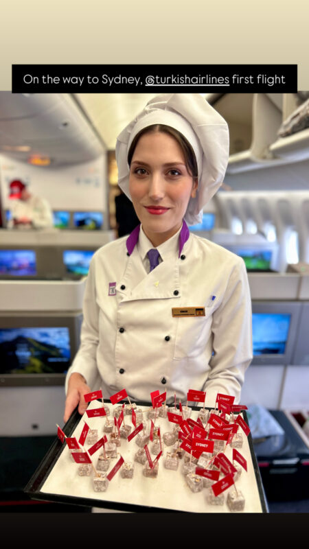 a woman wearing a chef's hat and holding a tray of small red flags