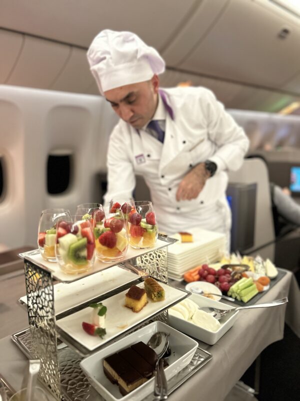 a chef standing behind a tray of food