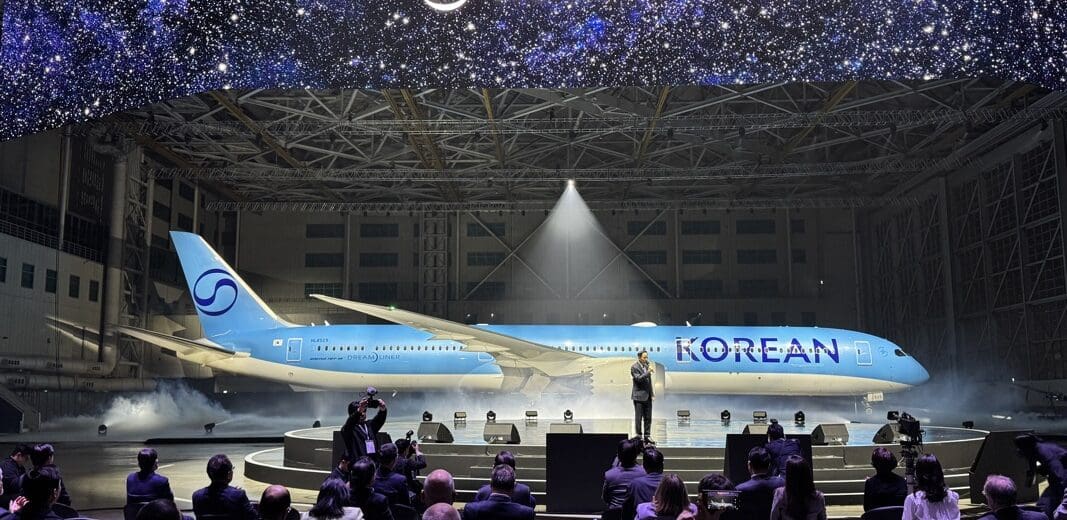 a group of people sitting in chairs in front of an airplane