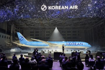 a group of people sitting in chairs in front of an airplane