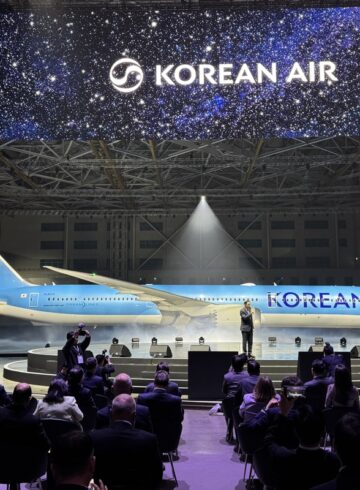 a group of people sitting in chairs in front of an airplane