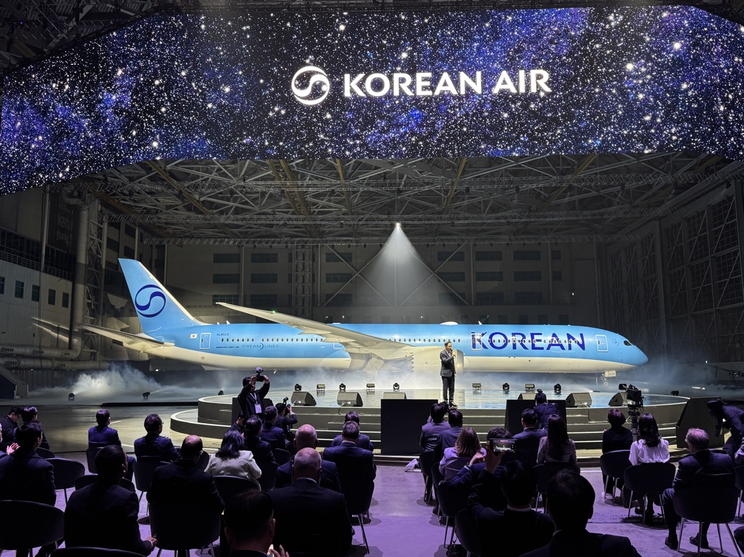 a group of people sitting in chairs in front of an airplane