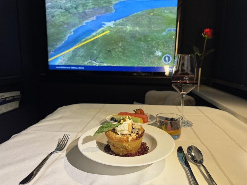 a plate of food on a table with a television screen in the background