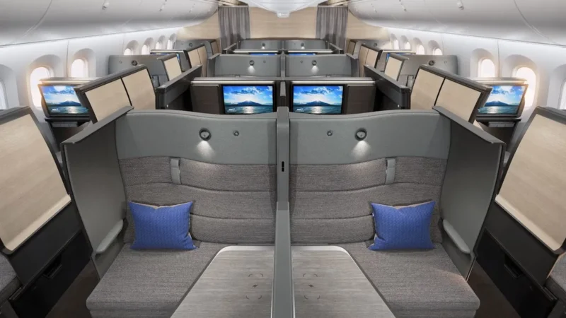 a row of seats with monitors on the back