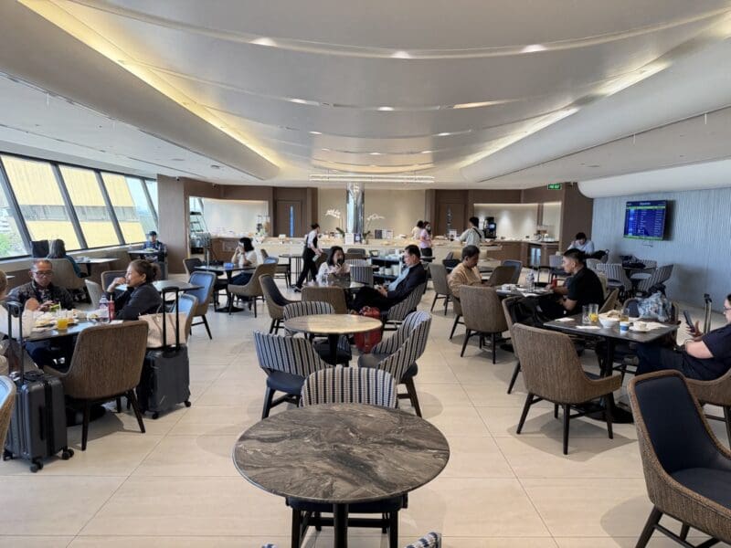 a group of people sitting at tables in a room with chairs and tables